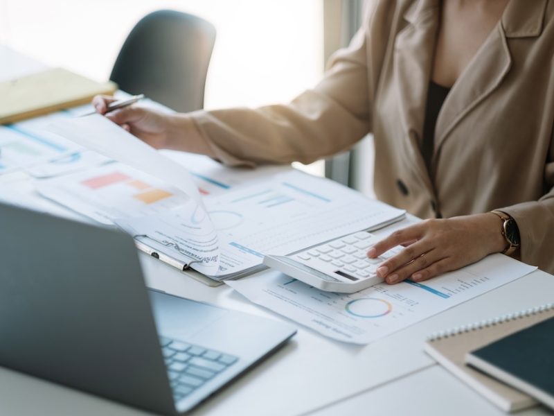 Close up woman planning budget, using calculator and laptop