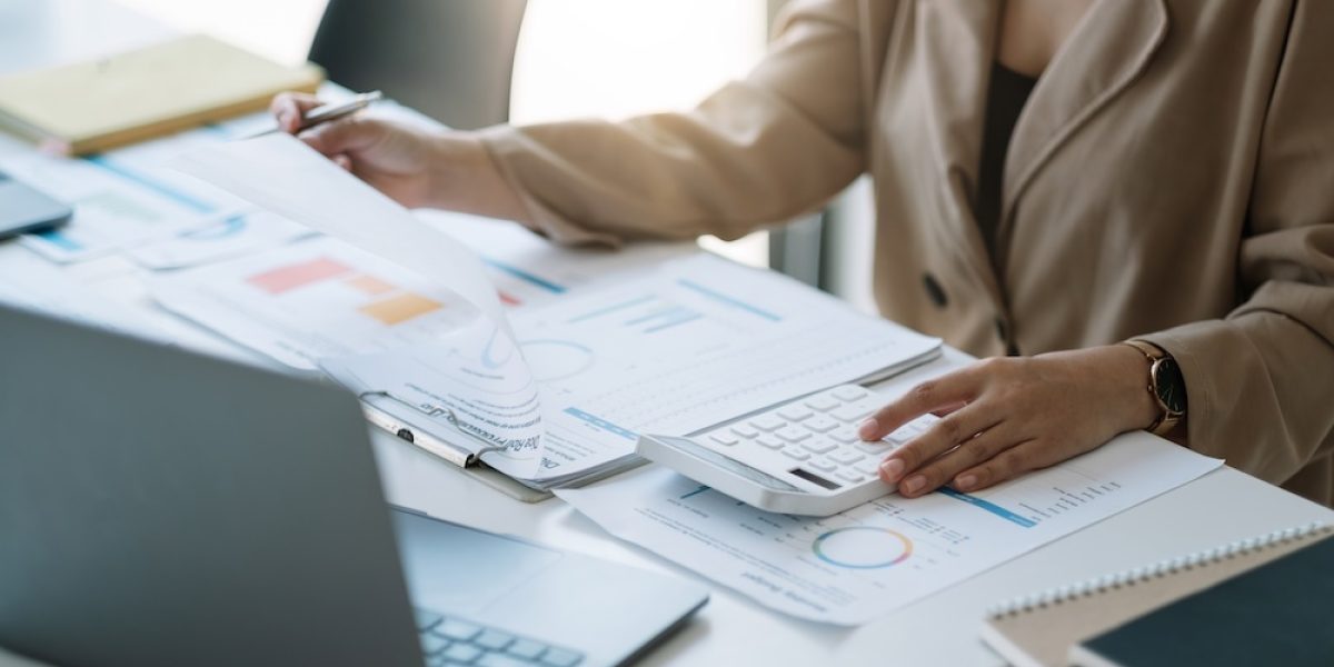 Close up woman planning budget, using calculator and laptop